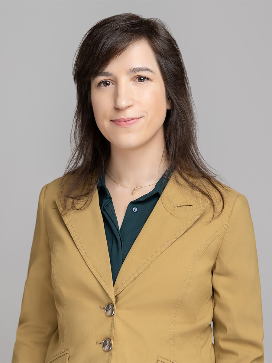 Womans headshot wearing a tan blazer