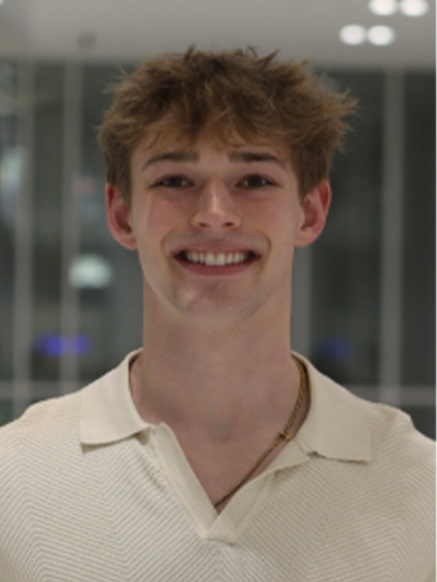 Headshot of a man smiling in a white collar shirt