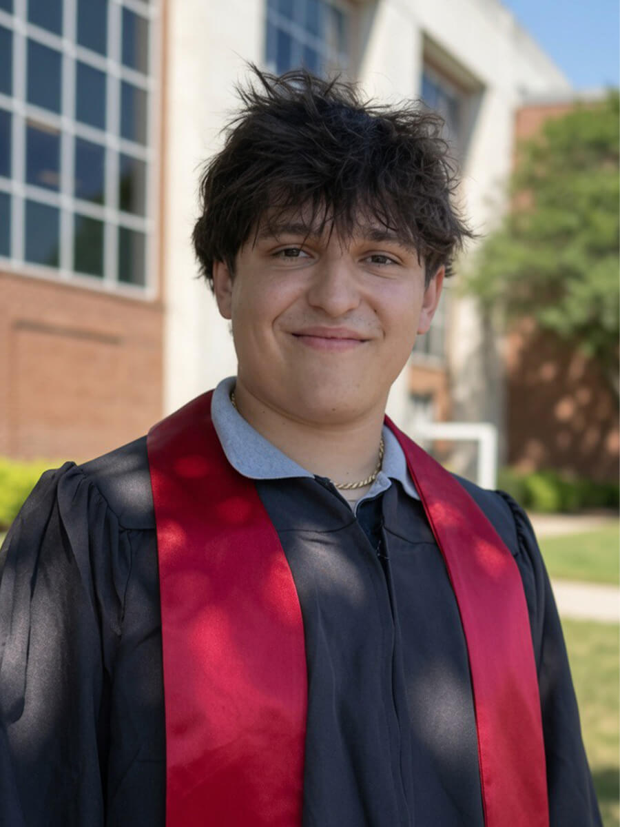 Headshot of a man wearing a black robe and red stoll for graduation
