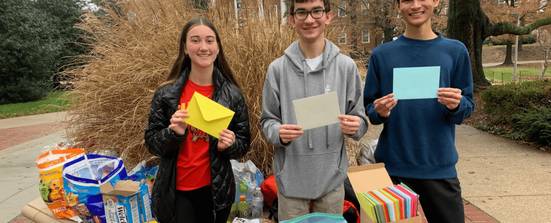 Students sitting around table with envelopes