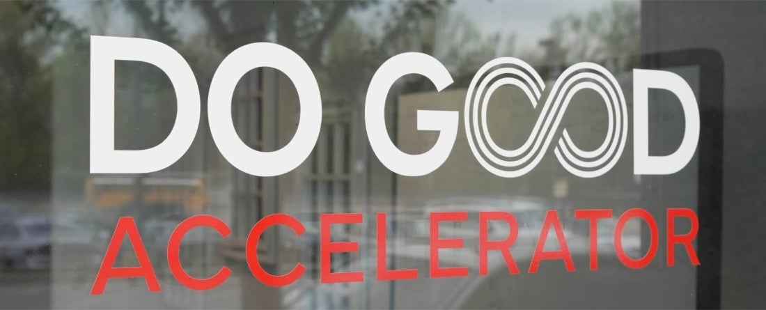 An image of the Do Good Accelerator sign on a glass door that leads into the building.